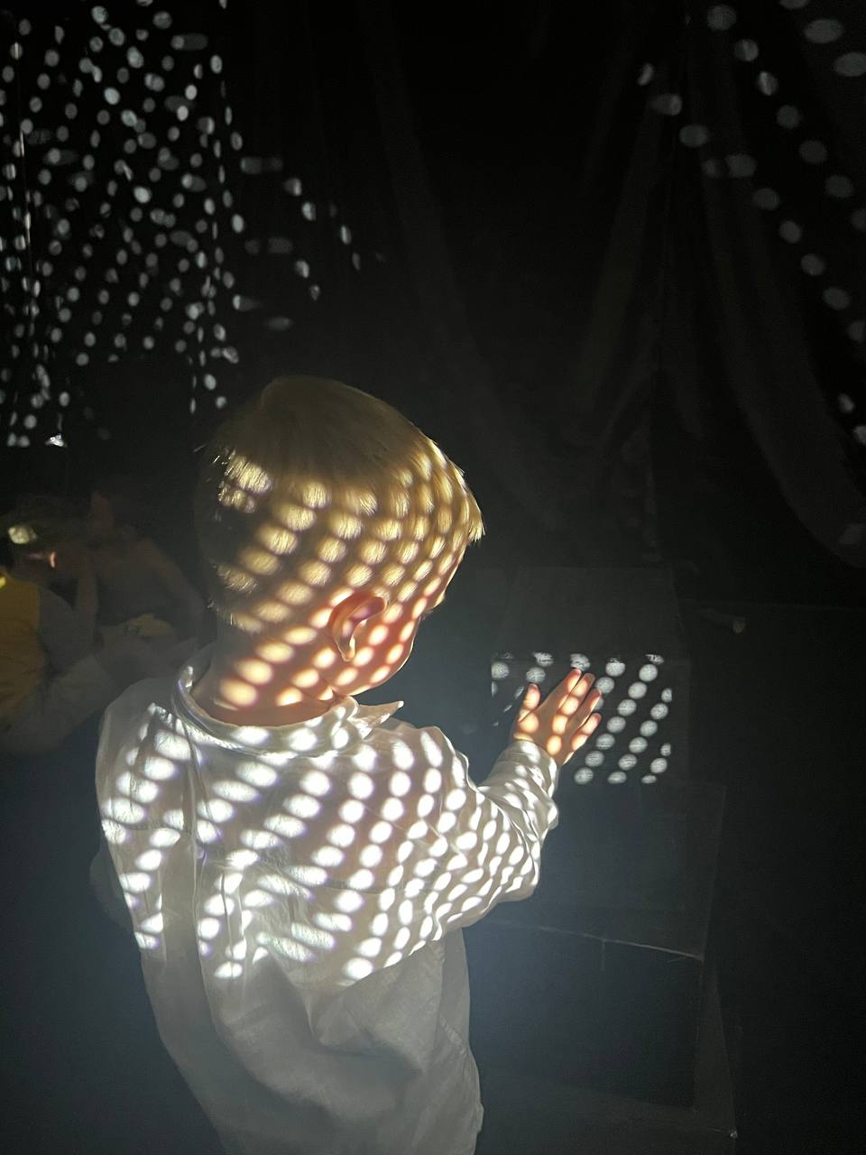 Child immersed in projected light patterns